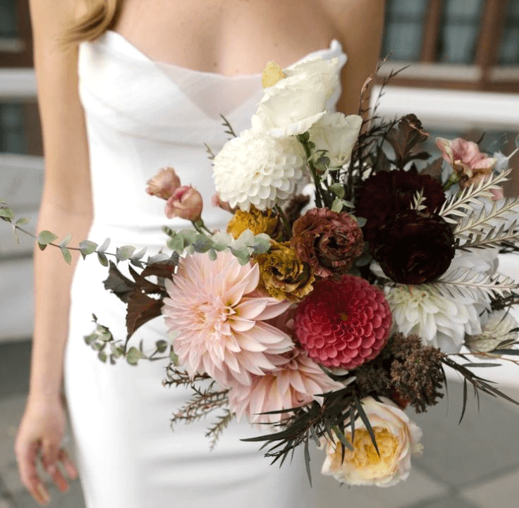 bride with a loose bouquet with peonies and roses