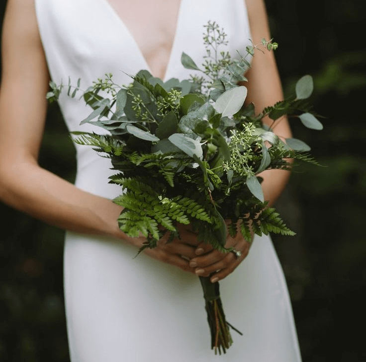 bride holding a greenery bouquet